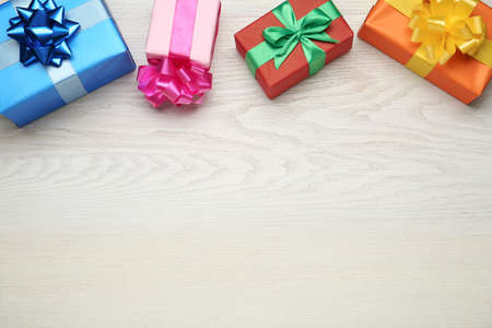 Many colorful gift boxes on white wooden table, flat lay. Space for textの写真素材