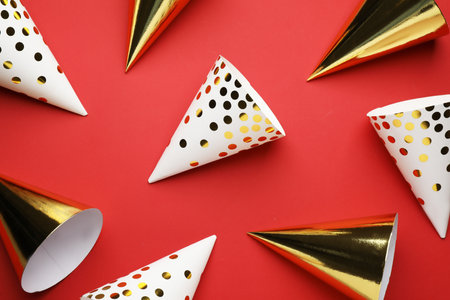 Bright party hats on red background, flat layの写真素材