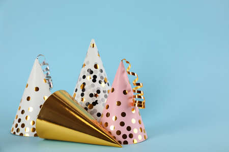 Bright party hats with streamers on light blue background. Space for textの写真素材