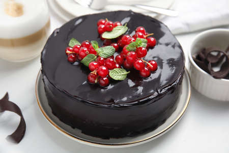 Tasty homemade chocolate cake with berries and mint on white tableの写真素材
