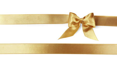 Beautiful golden ribbons with bow on white background, top viewの写真素材