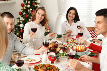 Happy family with their friends enjoying festive dinner at home. Christmas eve celebrationの写真素材