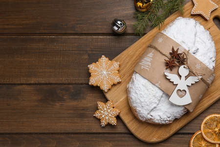 Traditional Christmas Stollen and festive decor on wooden table, flat lay. Space for text