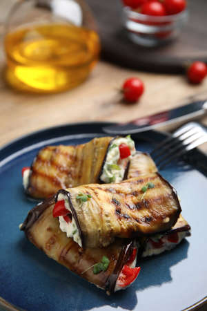 Delicious baked eggplant rolls with cheese, tomatoes and microgreens on plate, closeupの写真素材