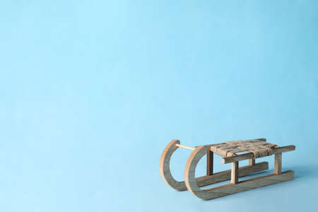 Beautiful decorative wooden sleigh on light blue background, space for textの写真素材