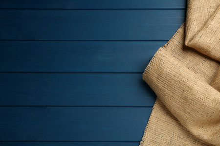 Natural burlap fabric on blue wooden table, top view. Space for textの写真素材