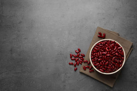 Raw red kidney beans with bowl and napkin on gray table, flat lay. Space for textの写真素材