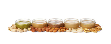 Jars with butter made of different nuts on white backgroundの写真素材