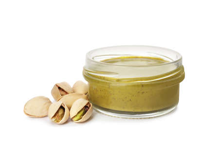 Jar with delicious pistachio butter and nuts on white backgroundの写真素材