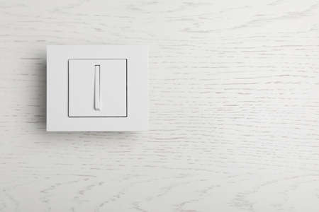 Light switch on white wooden background, top view. Space for textの写真素材