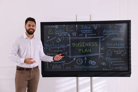 Business trainer using interactive board in meeting roomの写真素材
