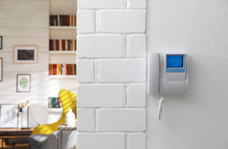 Modern intercom with camera installed on white wall indoorsの写真素材