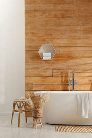 Bathroom interior with white tub and decor near wooden wallの写真素材