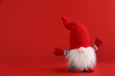 Cute Christmas gnome on red background. Space for textの写真素材