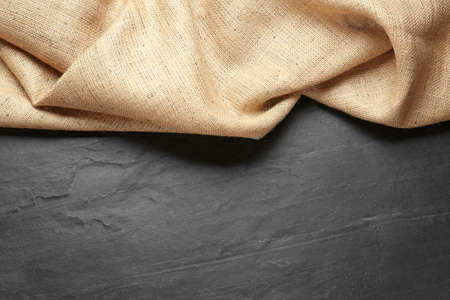 Natural burlap fabric on black table, top view. Space for textの写真素材