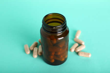 Gelatin capsules and bottle on turquoise background, closeupの写真素材