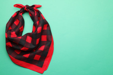 Tied red checkered bandana on turquoise background, top view. Space for textの写真素材