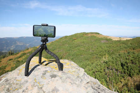 Taking video with modern phone on tripod in mountainsの写真素材
