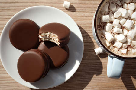 Tasty choco pies and cocoa with marshmallows on wooden table, flat layの写真素材