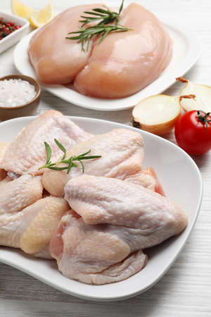 Fresh raw chicken meat and other products on white wooden tableの写真素材