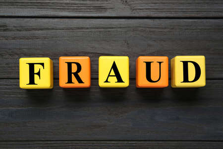Word Fraud of cubes with letters on black wooden background, flat layの写真素材