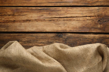 Natural burlap fabric on wooden table, top view. Space for textの写真素材