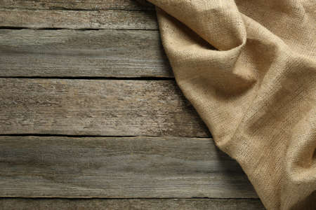 Natural burlap fabric on wooden table, top view. Space for textの写真素材