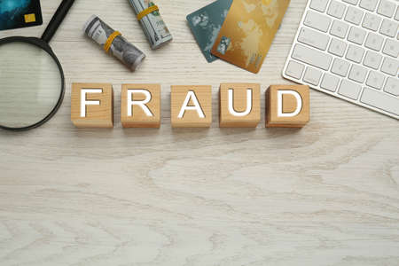 Flat lay composition with word Fraud on white wooden table, space for textの写真素材