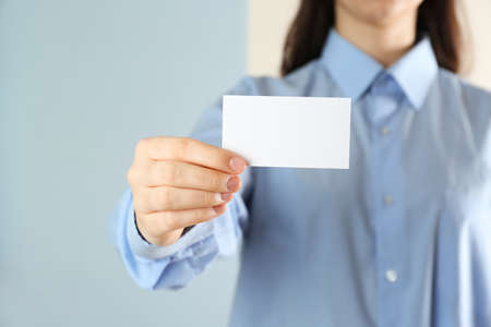 Woman holding blank business card on color background, closeup. Mockup for designの写真素材