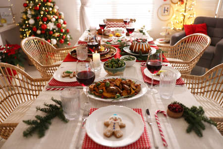 Festive dinner with delicious food and wine on table indoors. Christmas eve celebrationの写真素材