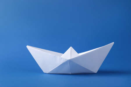 Handmade white paper boat on blue background. Origami artの写真素材