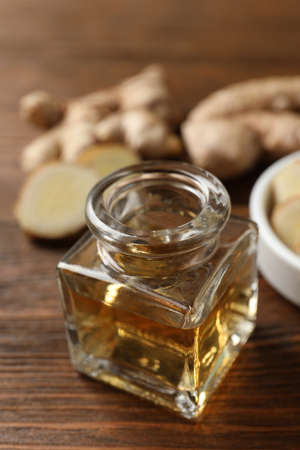 Ginger essential oil in bottle on wooden table, closeupの写真素材