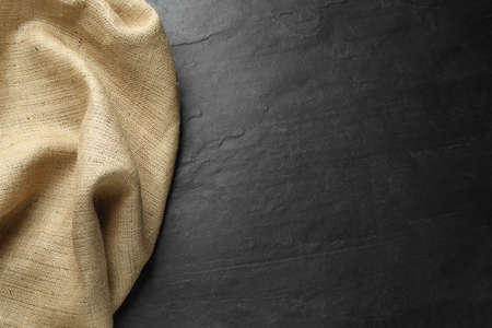 Natural burlap fabric on black table, top view. Space for textの写真素材