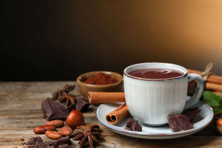 Composition with yummy hot chocolate in cup on wooden table, space for textの写真素材