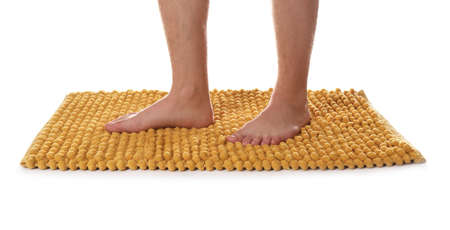 Man standing on soft orange bath mat against white background, closeupの写真素材