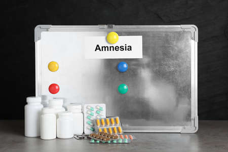 Magnetic board with word Amnesia and drugs on light gray table