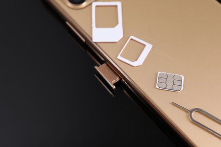 SIM card, smartphone and ejector on black background, closeupの写真素材