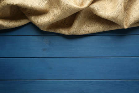 Natural burlap fabric on blue wooden table, top view. Space for textの写真素材