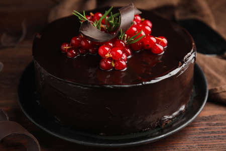Tasty homemade chocolate cake with berries and rosemary on wooden table, closeupの写真素材