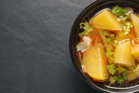 Bowl of tasty turnip soup on black table, top view. Space for textの写真素材