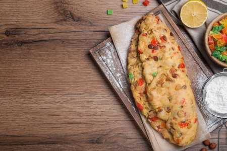 Unbaked Stollen with candied fruits and raisins on wooden table, flat lay. Space for text