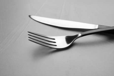 Fork and knife on gray table, closeupの写真素材