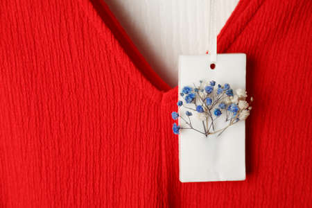 Scented sachet with flowers hanging near clothes, closeup viewの写真素材