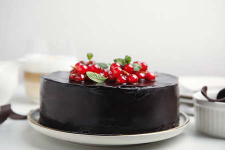 Tasty homemade chocolate cake with berries and mint on white table