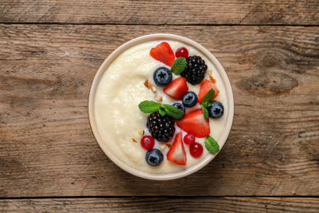Delicious semolina pudding with berries on wooden table, top viewの写真素材