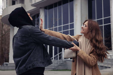 Woman fighting with thief while he trying to steal her bag on city street. Self defense conceptの写真素材