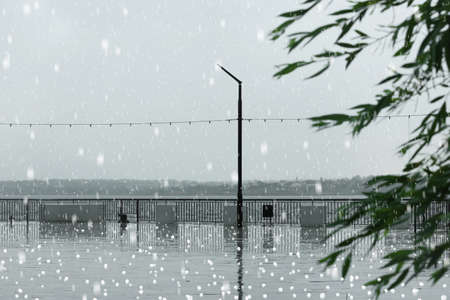 Empty city embankment on rainy day with hail