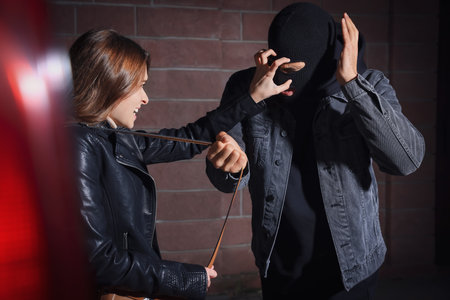 Woman fighting with thief while he trying to steal her bag outdoors at night. Self defense concept