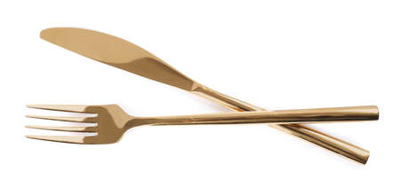 New shiny golden fork and knife on white background, top view