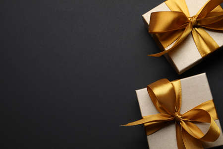 Golden gift boxes on black background, flat lay. Space for textの写真素材